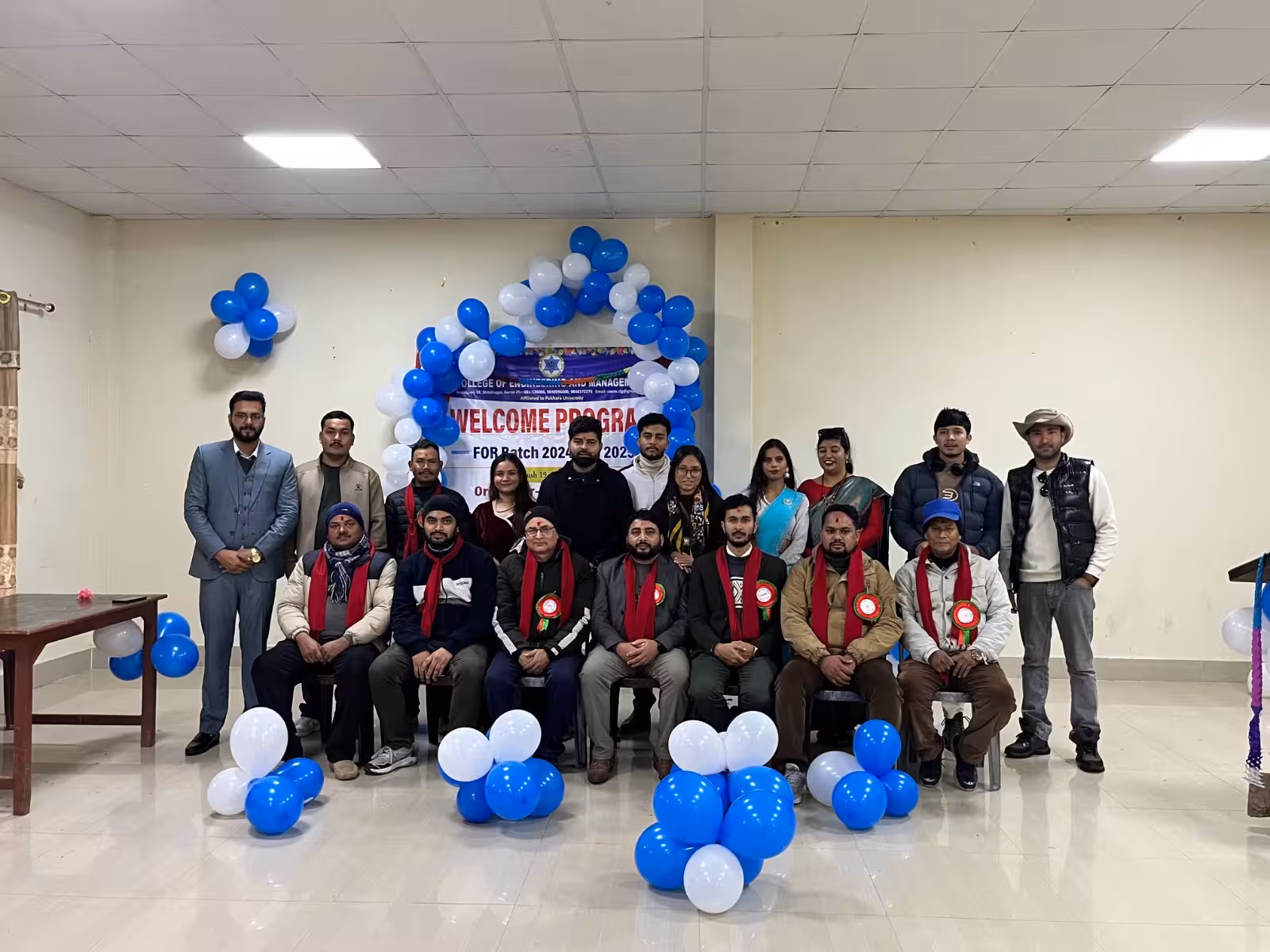 A welcome programme for a new intake, students seated in rows under blue and white balloons