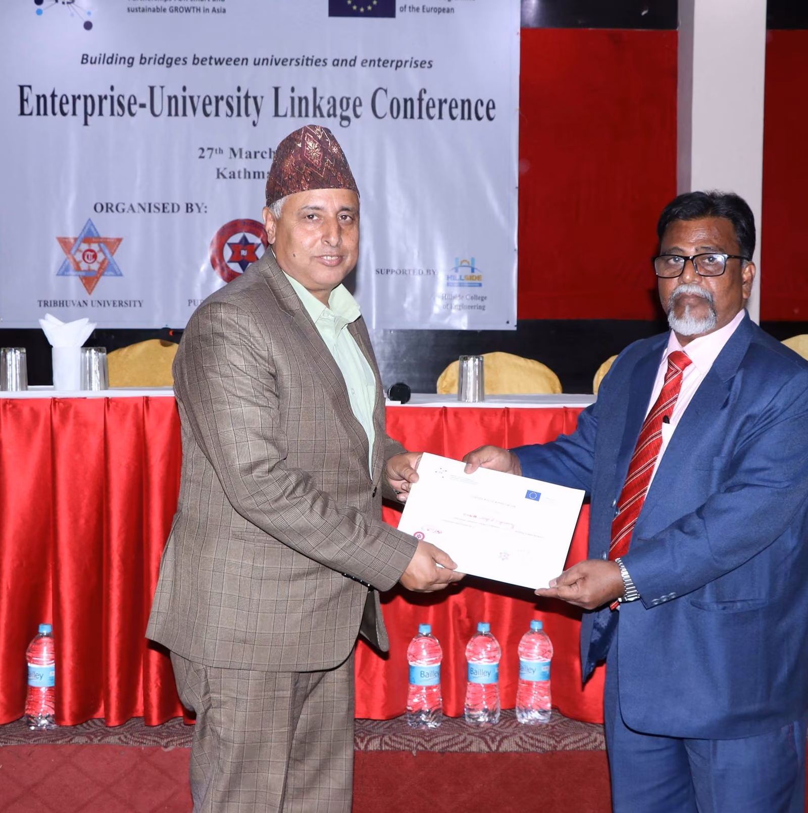 A certificate handed over at the Enterprise-University Linkage Conference, its banner behind