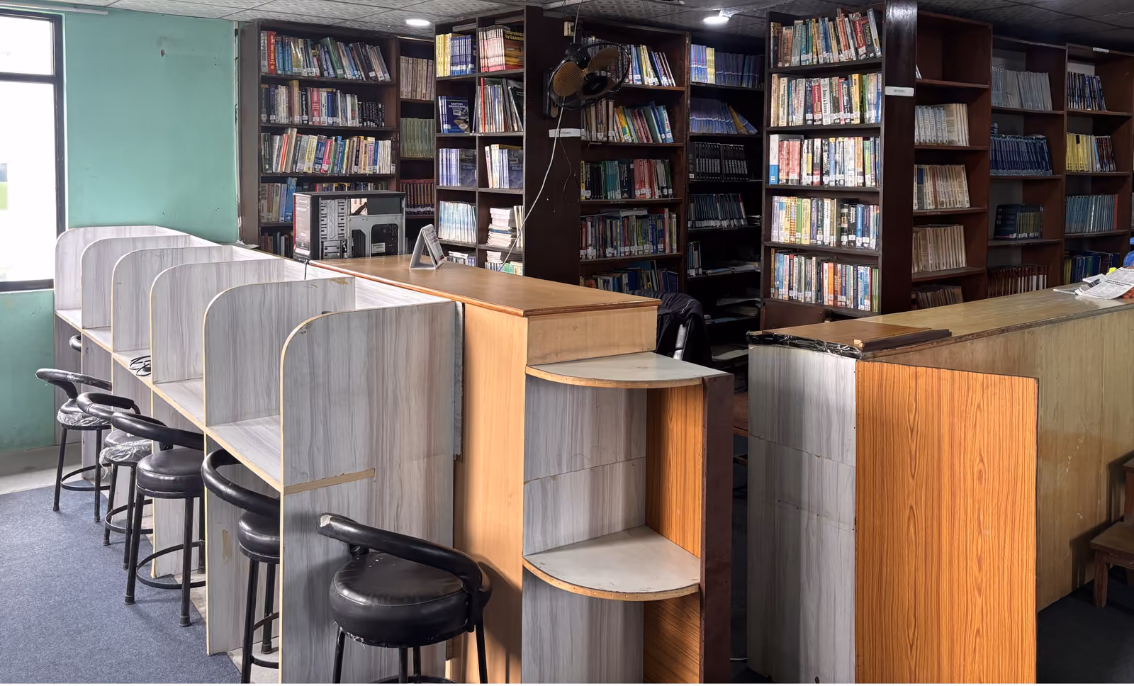 The library's reading carrels down one wall and its book stacks along the other