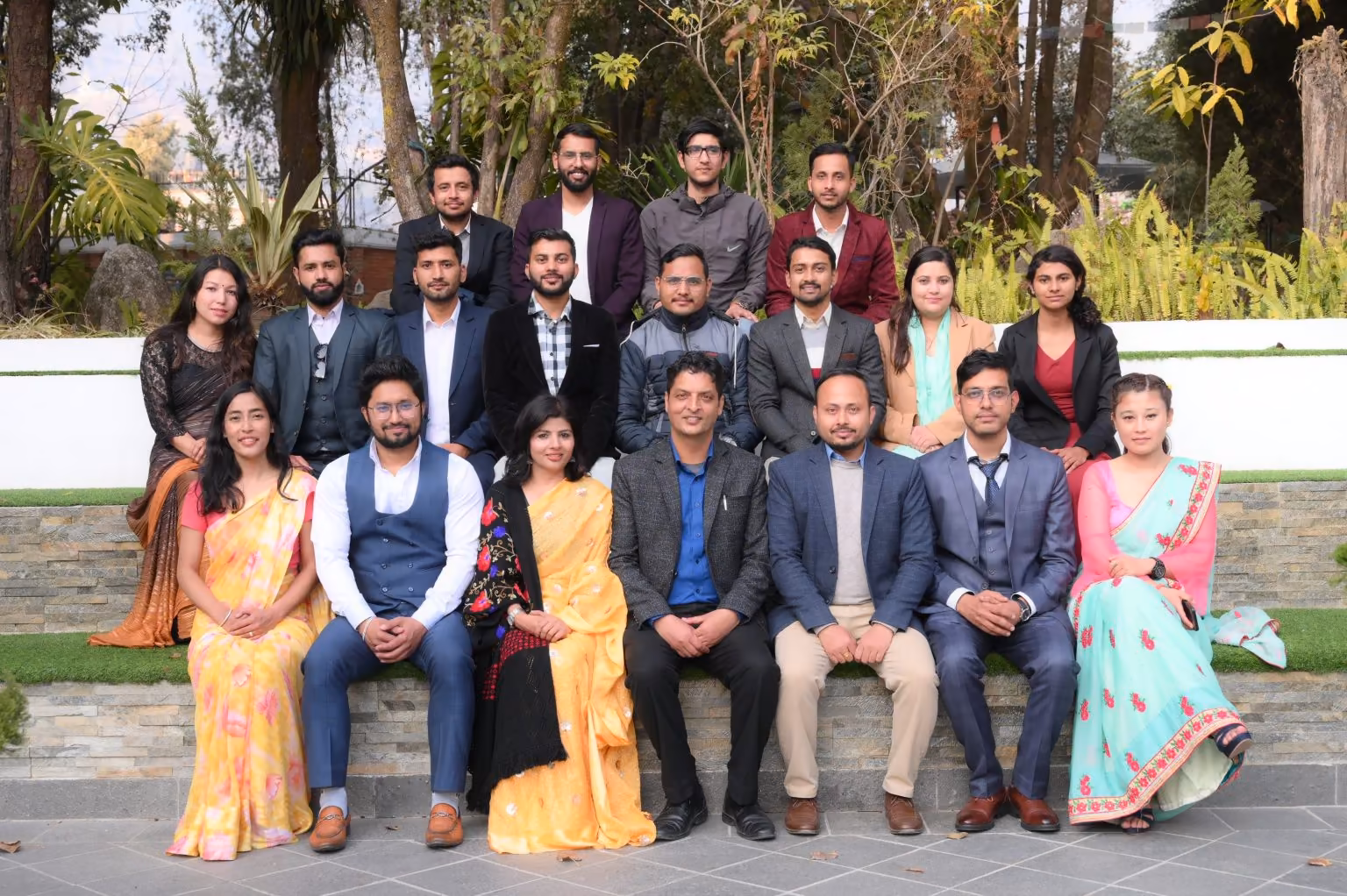 Staff photographed together on the college path, garden and palm trees behind