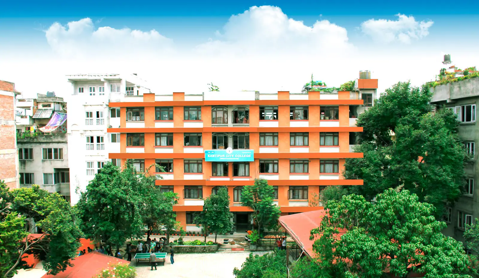 The college's orange block above the trees, its balconies stacked along the front