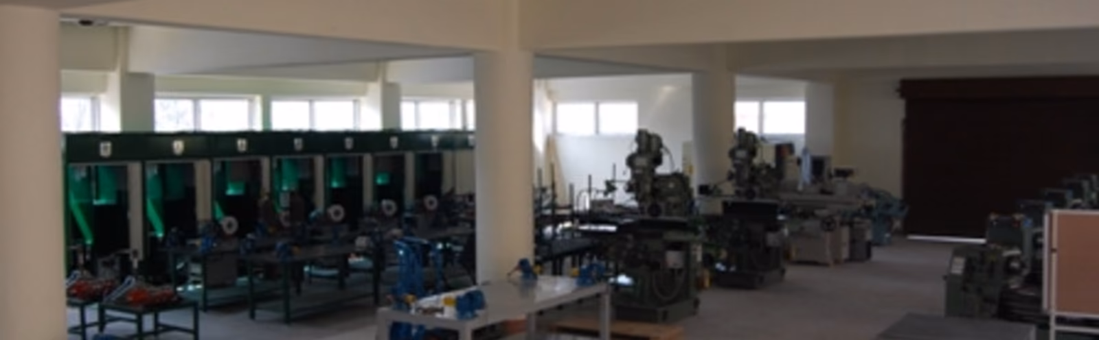 A machine workshop of lathes and milling machines ranged down a long hall