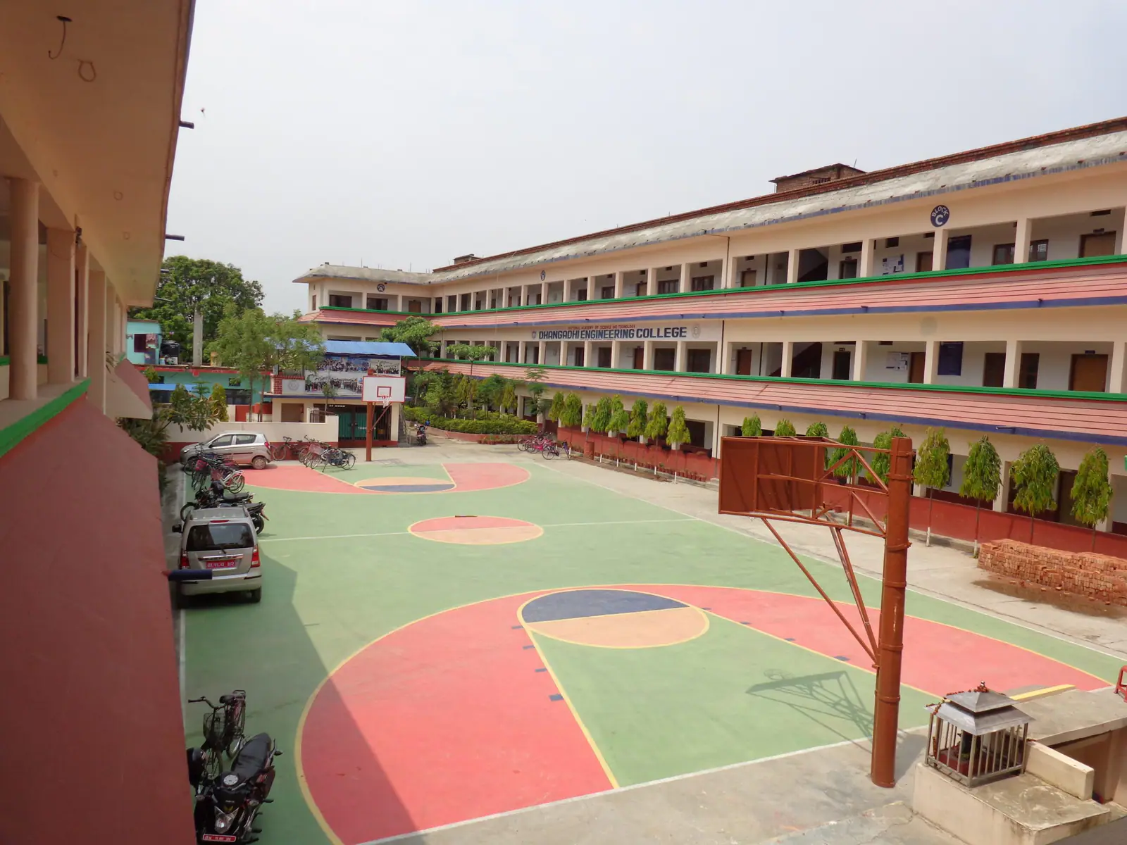 A long three-storey block along the courtyard, its painted basketball court in the foreground
