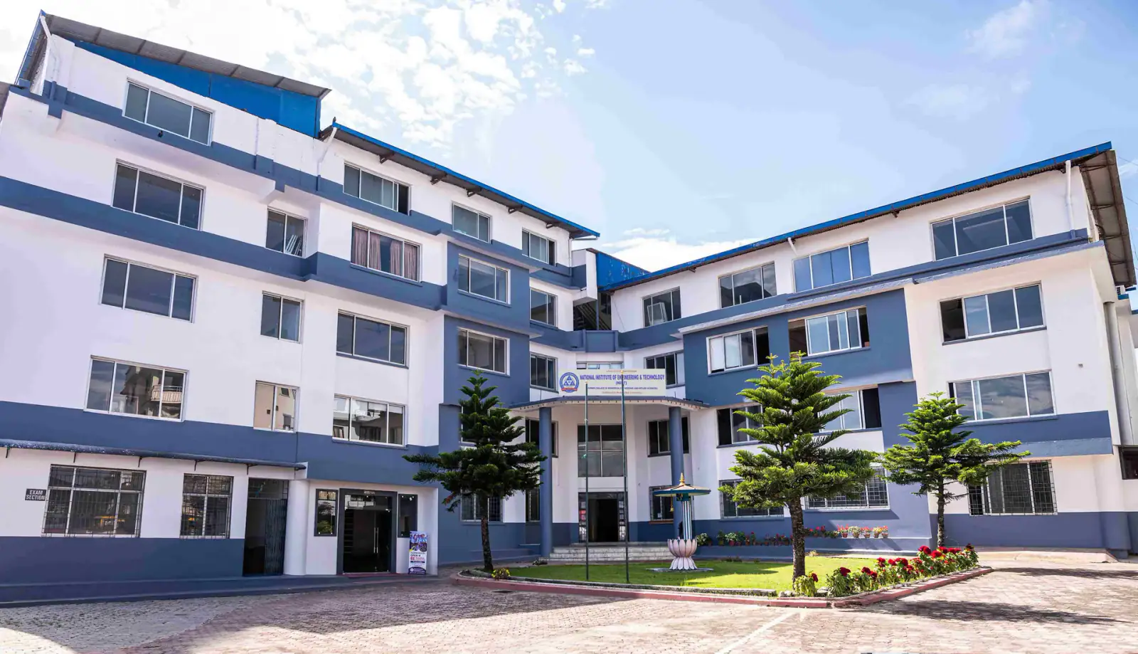 The institute's blue and white blocks round a paved courtyard with young trees