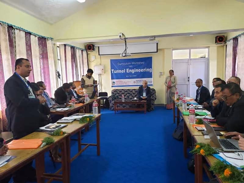A curriculum workshop on tunnel engineering, participants at tables under its banner