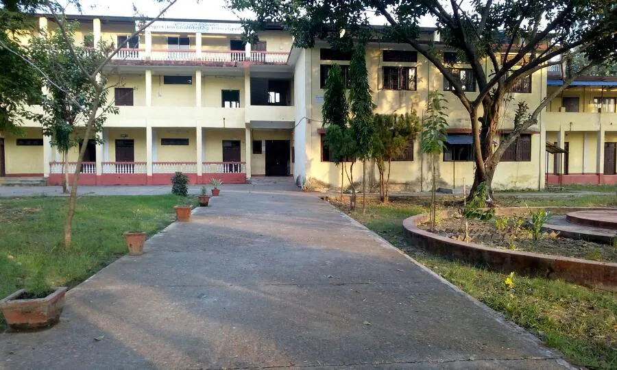 The school's long two-storey block along its drive, potted plants down the path